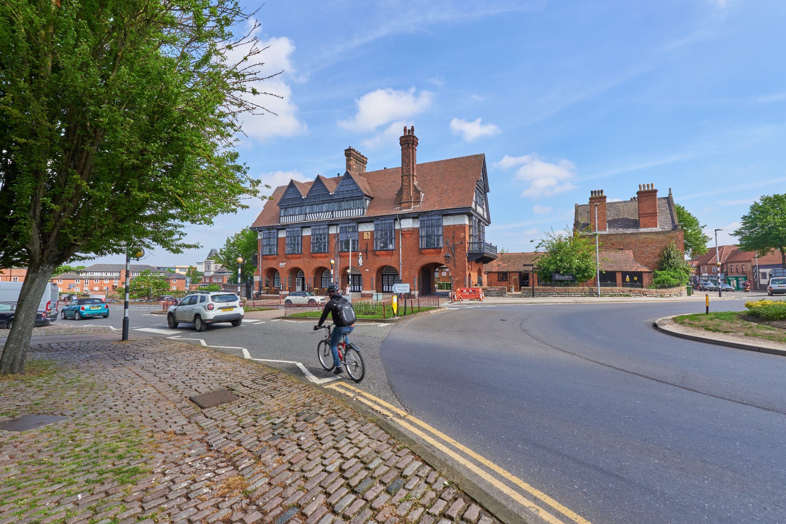 Cyclist and car exiting a large roundabout