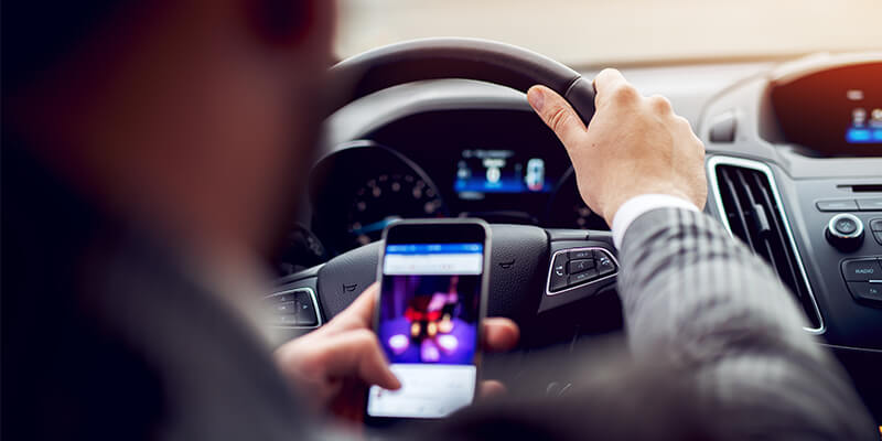 driver using mobile phone behind the wheel