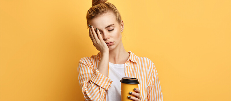 tired girl holding coffee cup