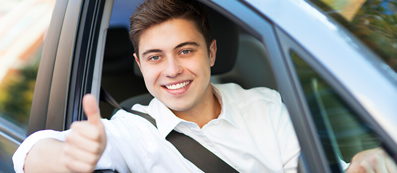 boy with thumbs up in car