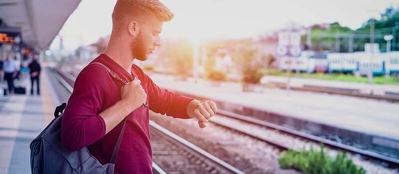 man waiting for train checking watch