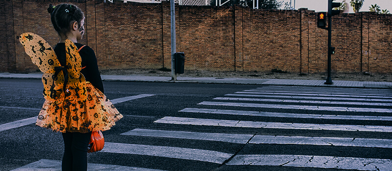 girl in halloween costume at zebra crossing