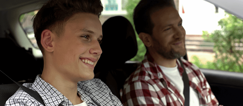 father teaching son to drive