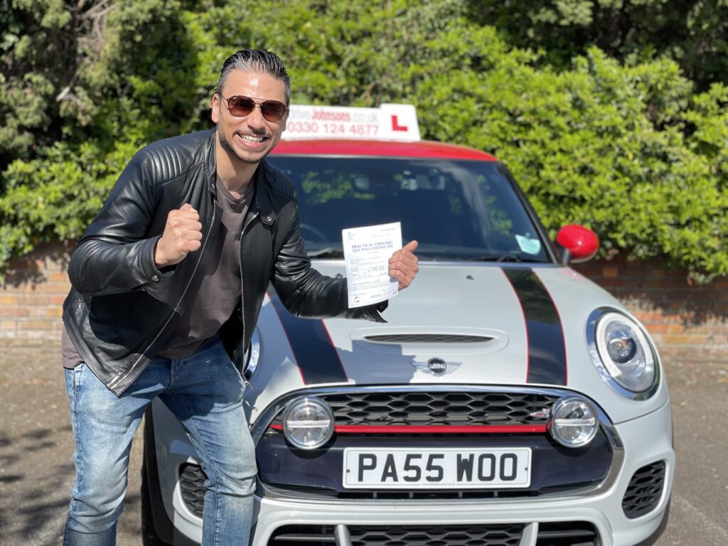 Ricky Norwood celebrating driving test pass next to mini