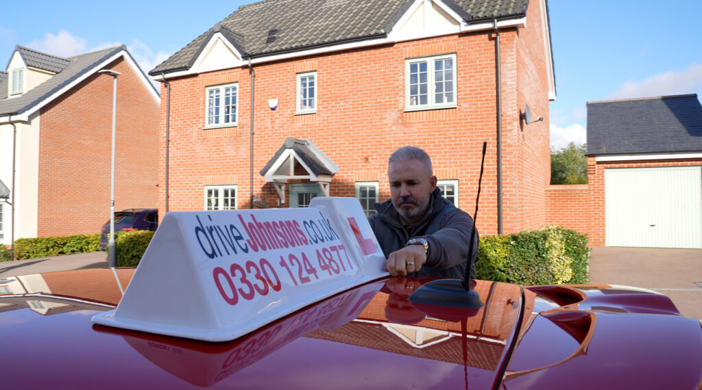 Anthony Johnson putting driveJohnson's roof sign on car
