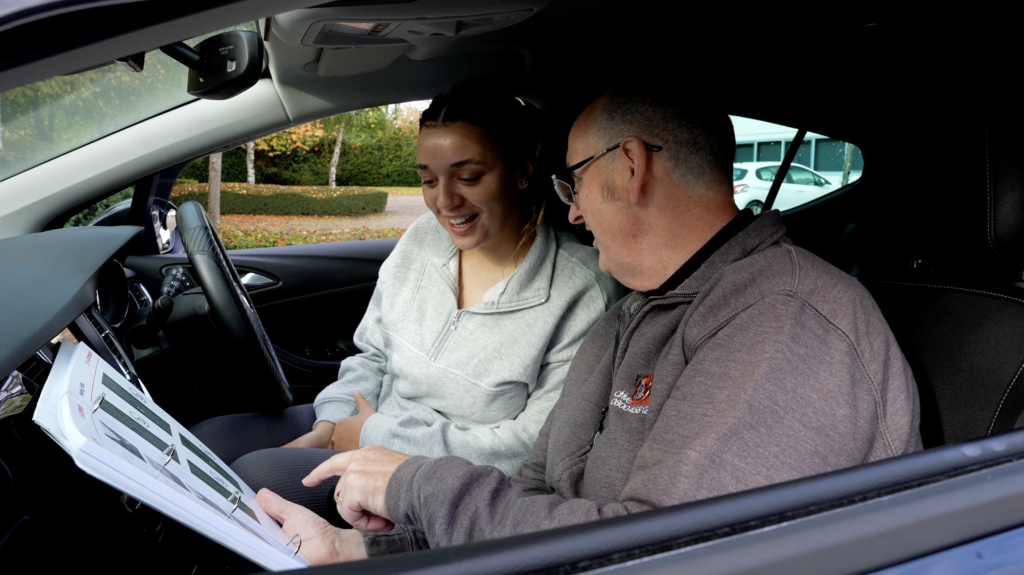 Driving instructor showing pupil lesson planner