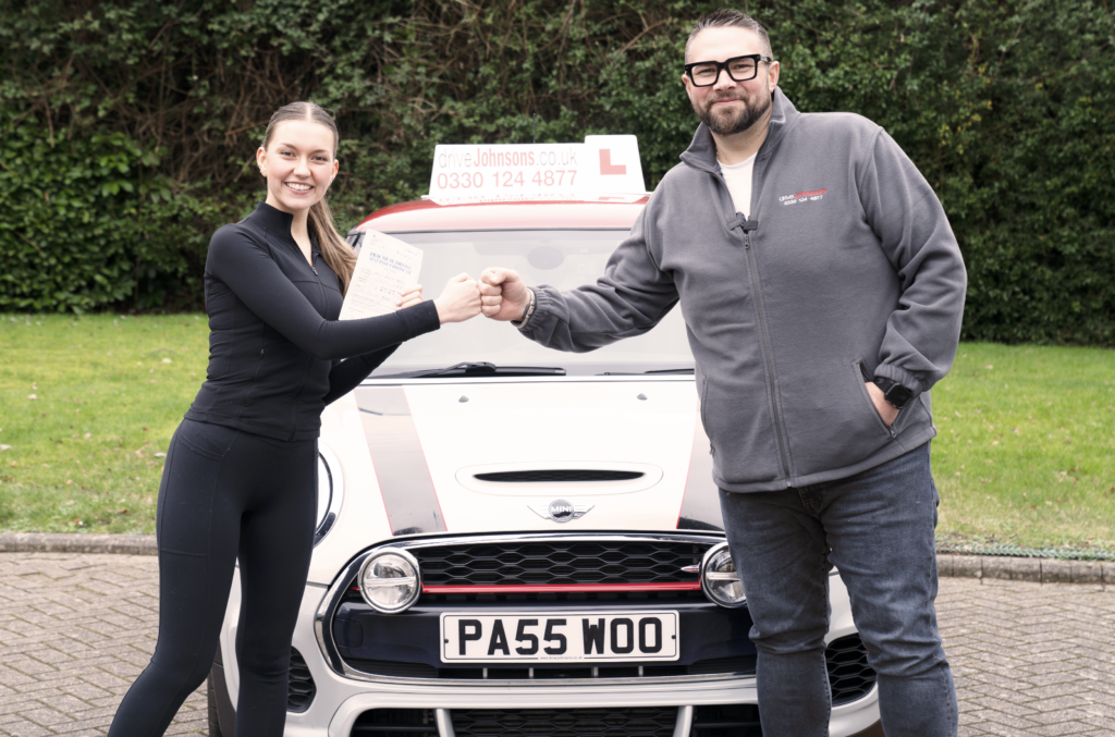 Learner and driving instructor fist bumping