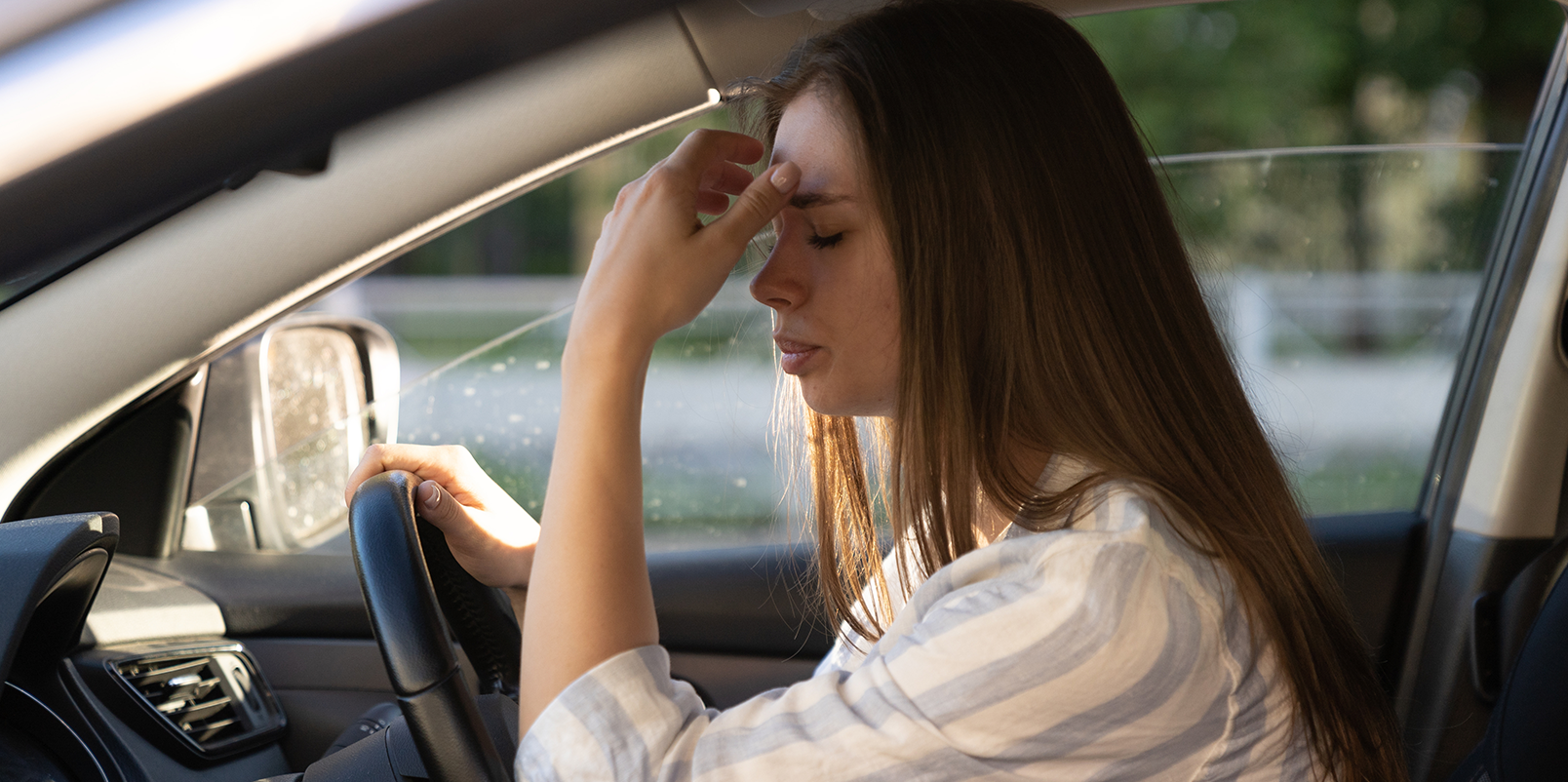 Stressed woman behind the steering wheel of a car