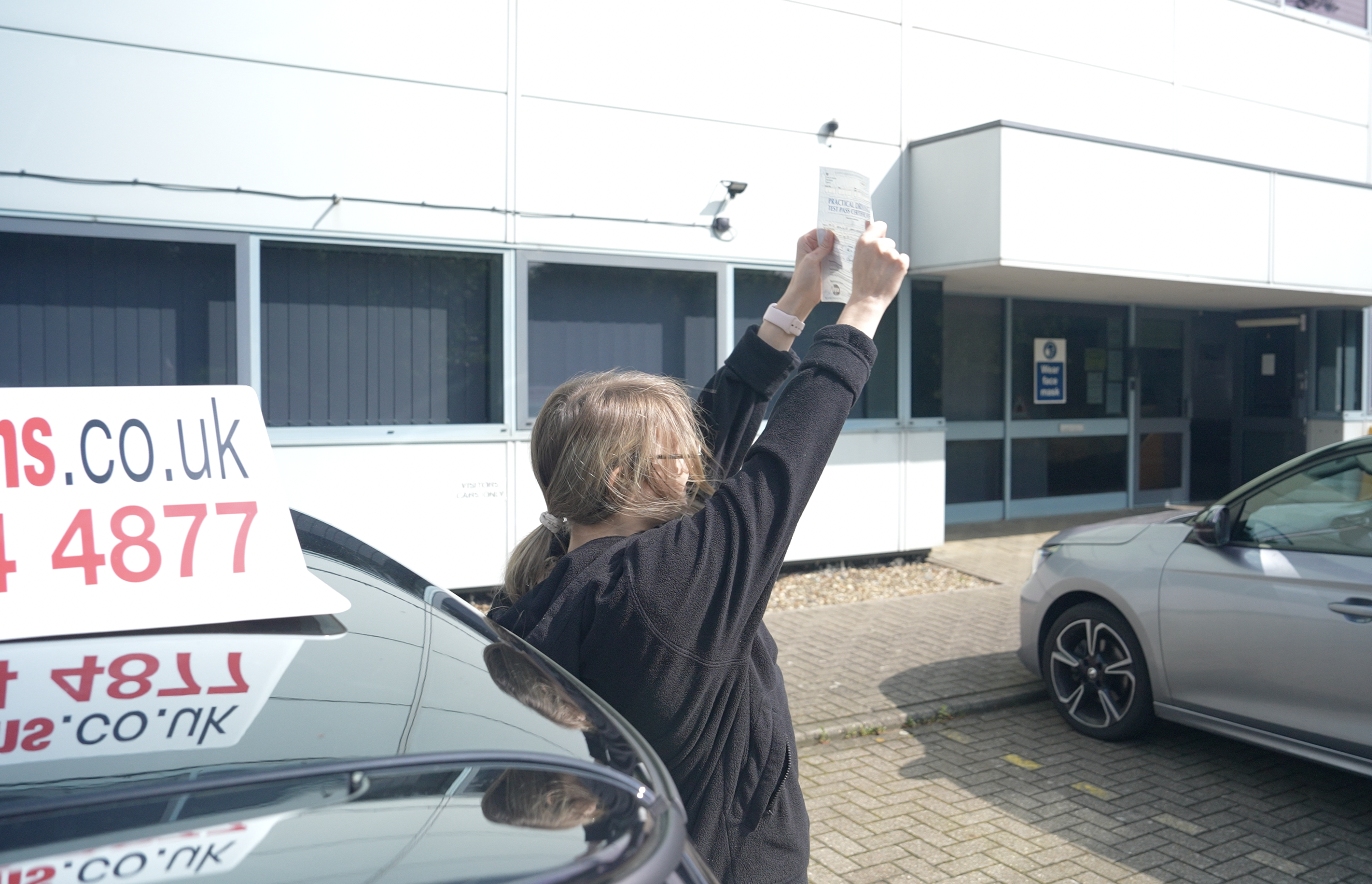 Pupil who has passed holding up their pass certificate