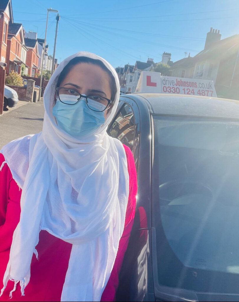 Our winning instructor, Naila Mansoor, next to her car with its roof sign