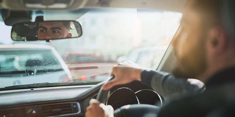 Driver's face being reflected in rear view mirror when driving