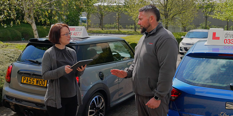 Driving examiner speaking to driving instructor