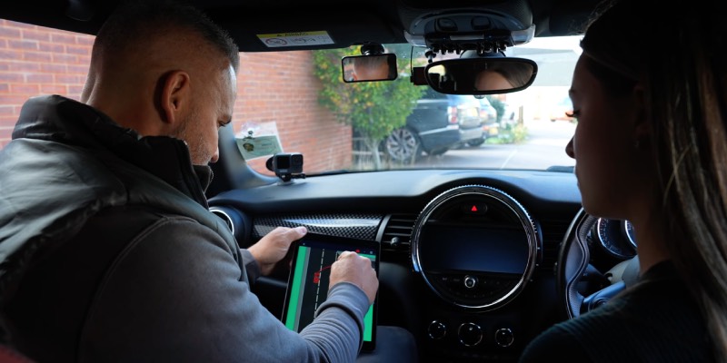 Learner and instructor in the car, looking at a diagram on a tablet
