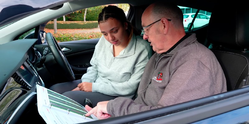 Learner and instructor talking whilst pointing to diagram on page
