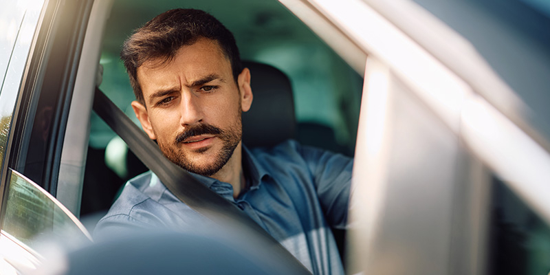 Driver looking in car side mirror