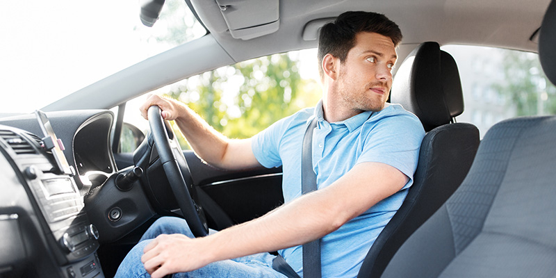 Driver looking over his shoulder as he reverses