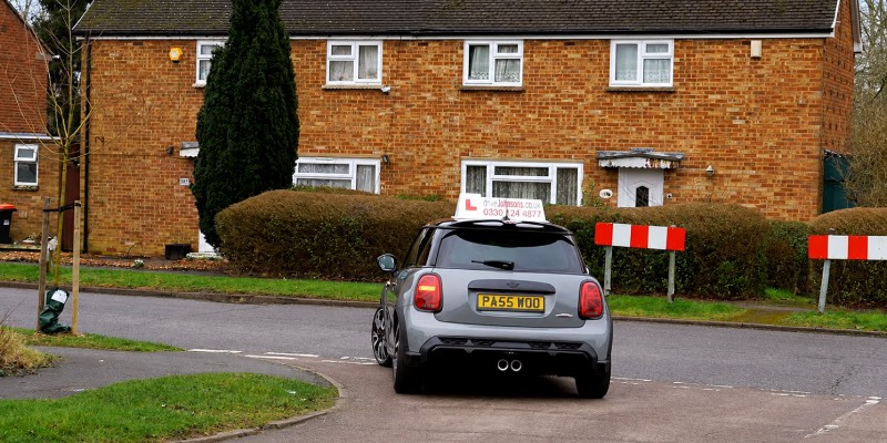 A mini indicating and turning left at a junction.