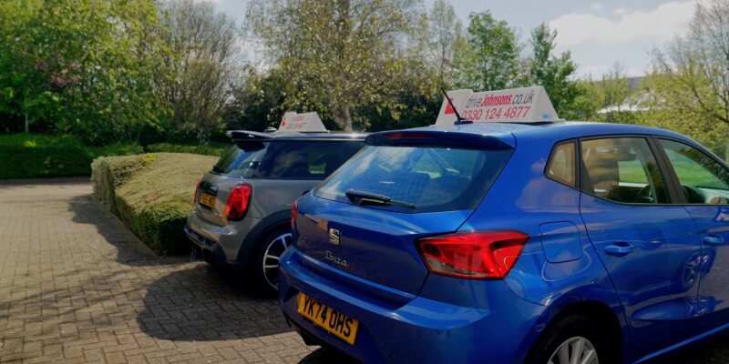 Two driveJohnson's cars parked next to eachother