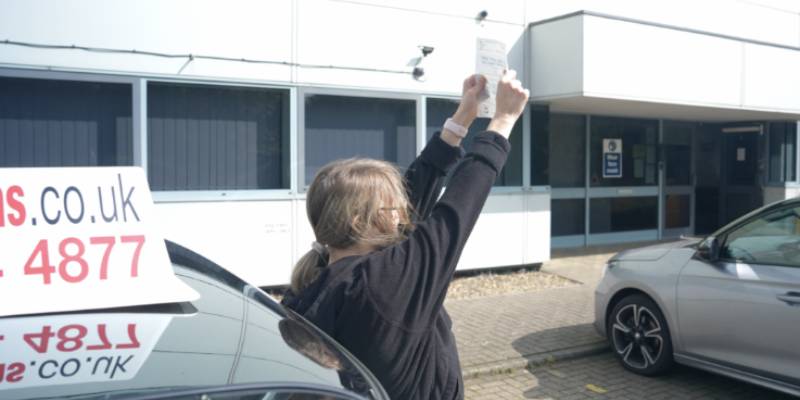 Pupil who has passed holding up their pass certificate