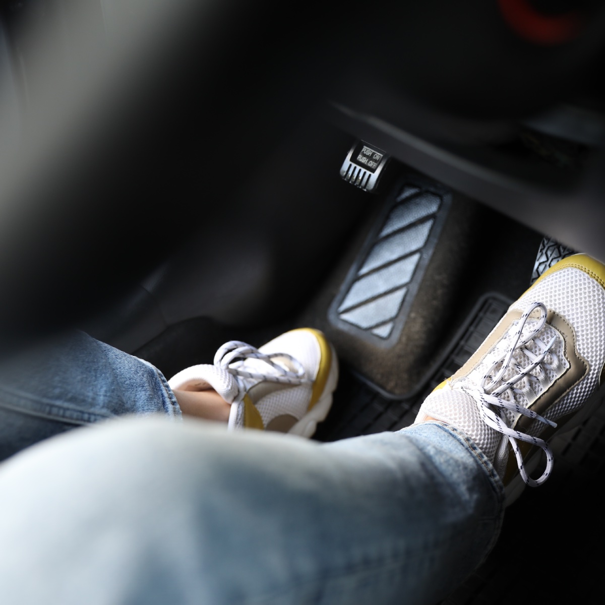 Foot pushing on brake pedal in the car