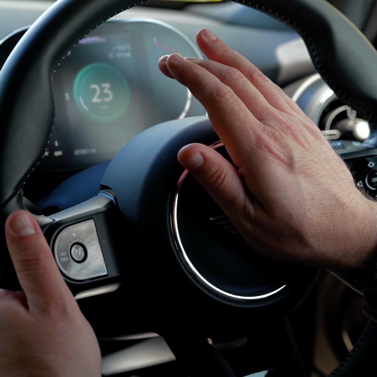 Hand pressing to sound the horn on the steering wheel