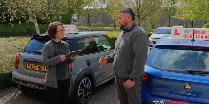 Instructor and examiner discussing near learner car