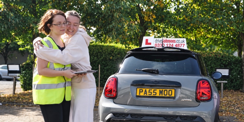 Learner hugging her driving test examiner after passing her driving test