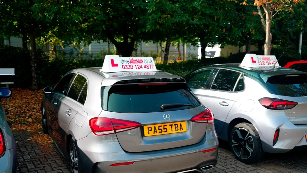 Cars parked with driveJohnson's roof signs displayed