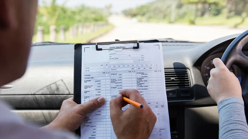 Examiner marking driving test sheet in the car